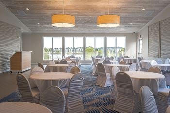 A large room with tables and chairs and a podium